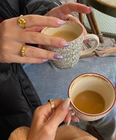 two women holding coffee cups in their hands