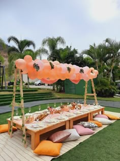 a picnic table with balloons and food on it