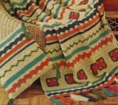 a crocheted blanket sitting on top of a wooden floor next to a basket