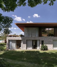 the house is made out of stone and has sliding glass doors that open up to let in natural light