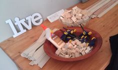 a bowl filled with construction tools sitting on top of a wooden table next to a sign that says live