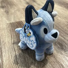 a blue stuffed animal sitting on top of a wooden floor