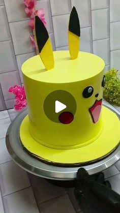 a yellow cake with black ears on top