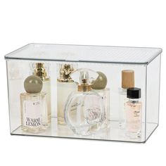 an open clear box containing three different perfumes