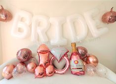 balloons and decorations are arranged on a bed with the word bride spelled out in large letters