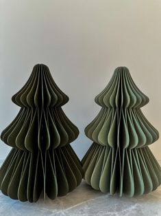 two green paper christmas trees sitting next to each other