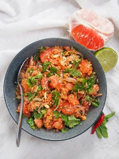 a bowl filled with food next to a slice of lime