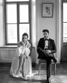 a black and white photo of a man and woman in formal wear sitting next to each other