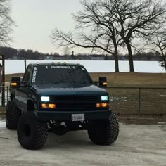 a black truck parked on top of a dirt road