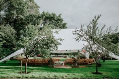 an outdoor wedding venue set up in the middle of a field with trees and chairs