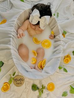 a baby in a bath with orange slices