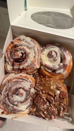 a box filled with cinnamon rolls covered in icing