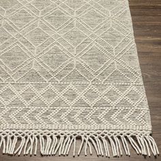 a white rug with fringes on the floor