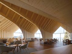 the interior of a restaurant with wooden walls and flooring, tables and chairs are arranged in rows