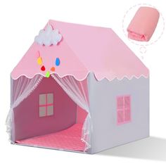 a pink and white doll house with curtains on the roof, bedding and pillows