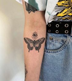 a woman's arm with a butterfly tattoo on the left side of her arm