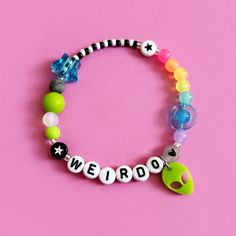 Personalise with any name or word. Rainbow space themed bracelet featuring the cutest laser cut acrylic alien charm on a stainless steel jump ring.  Silicone bead, planet bead and sliding star add an extra sensory tactile detail to this bracelet.  Choose from the size options at checkout. Space Kandi, Alien Bracelet, Plastic Bead Bracelets, Glass Beads Bracelet Ideas, Bead Bracelet Words Ideas, Bracelet Beads Ideas, Bracelet Ideas Beads, Cool Bracelet Ideas, Silicon Bracelet