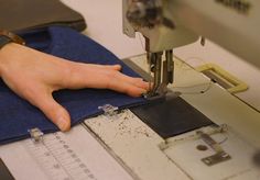 a person is using a sewing machine to sew something on a piece of fabric