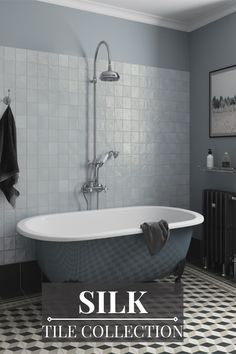 a bath tub sitting on top of a black and white tile floor next to a radiator