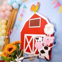 there is a red barn with flowers and balloons on the wall in front of it