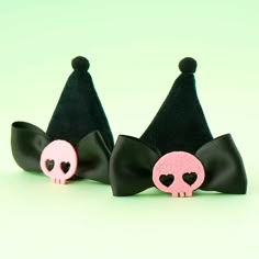 two black and pink hair bows with skulls in the middle one has a skull on it's head