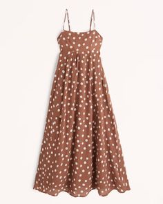 a brown polka dot dress hanging on a hanger, with white dots all over it