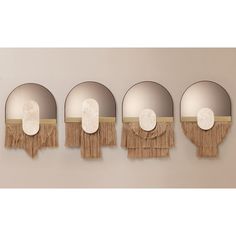 four round mirrors with tassels hanging on the wall