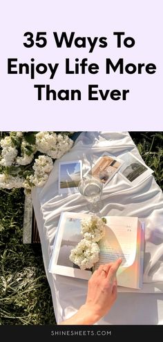 a person laying on the ground with flowers and an open book in front of them