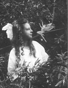 an old black and white photo of a woman in the woods with birds flying overhead