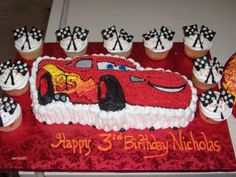 a birthday cake with cars and cupcakes on it