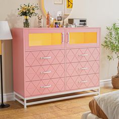 a pink and yellow dresser in a room with a mirror on the wall above it