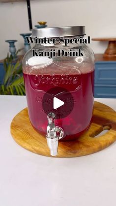 a glass jug filled with liquid sitting on top of a wooden tray