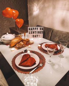 a table set for valentine's day with heart shaped balloons