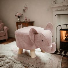 an elephant shaped ottoman sitting in front of a fire place