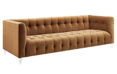 a brown couch with white legs and buttons on it