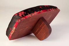 a wooden object with red and black fabric on it