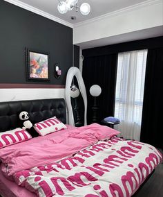 a pink and white bed in a bedroom next to a window with black drapes