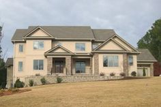 a large house sitting on top of a lush green field