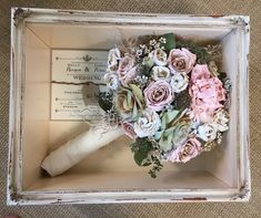 a bridal bouquet in a box on the floor