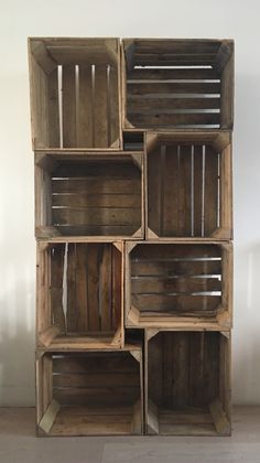 a stack of wooden crates sitting on top of a white floor next to a wall