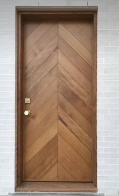 a wooden door on the side of a white brick building