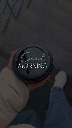 a person holding a cup with the words good morning written on it in front of them