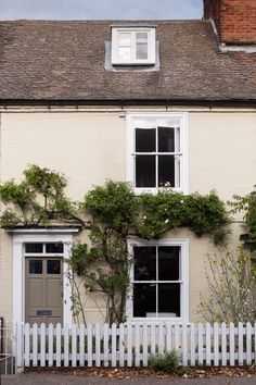 a white house with vines growing on it's side