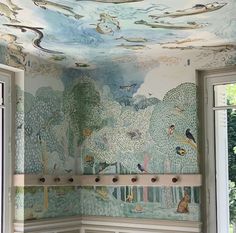 the ceiling is painted with birds and trees