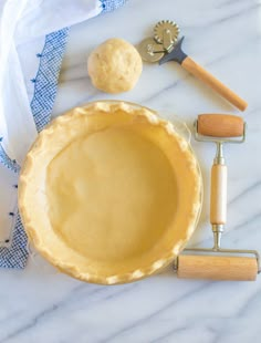 an uncooked pie sitting on top of a table next to other baking tools