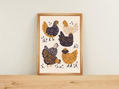 there are chickens on the shelf next to the framed art print that is hanging on the wall