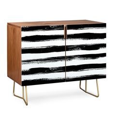 a black and white striped cabinet with gold legs