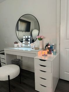 a white desk topped with a mirror next to a chair