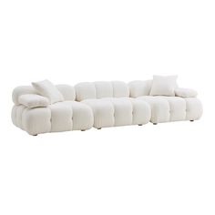 a large white couch with pillows on it's back and arms, sitting against a white background