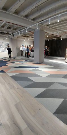 people are standing in an open space with colorful flooring